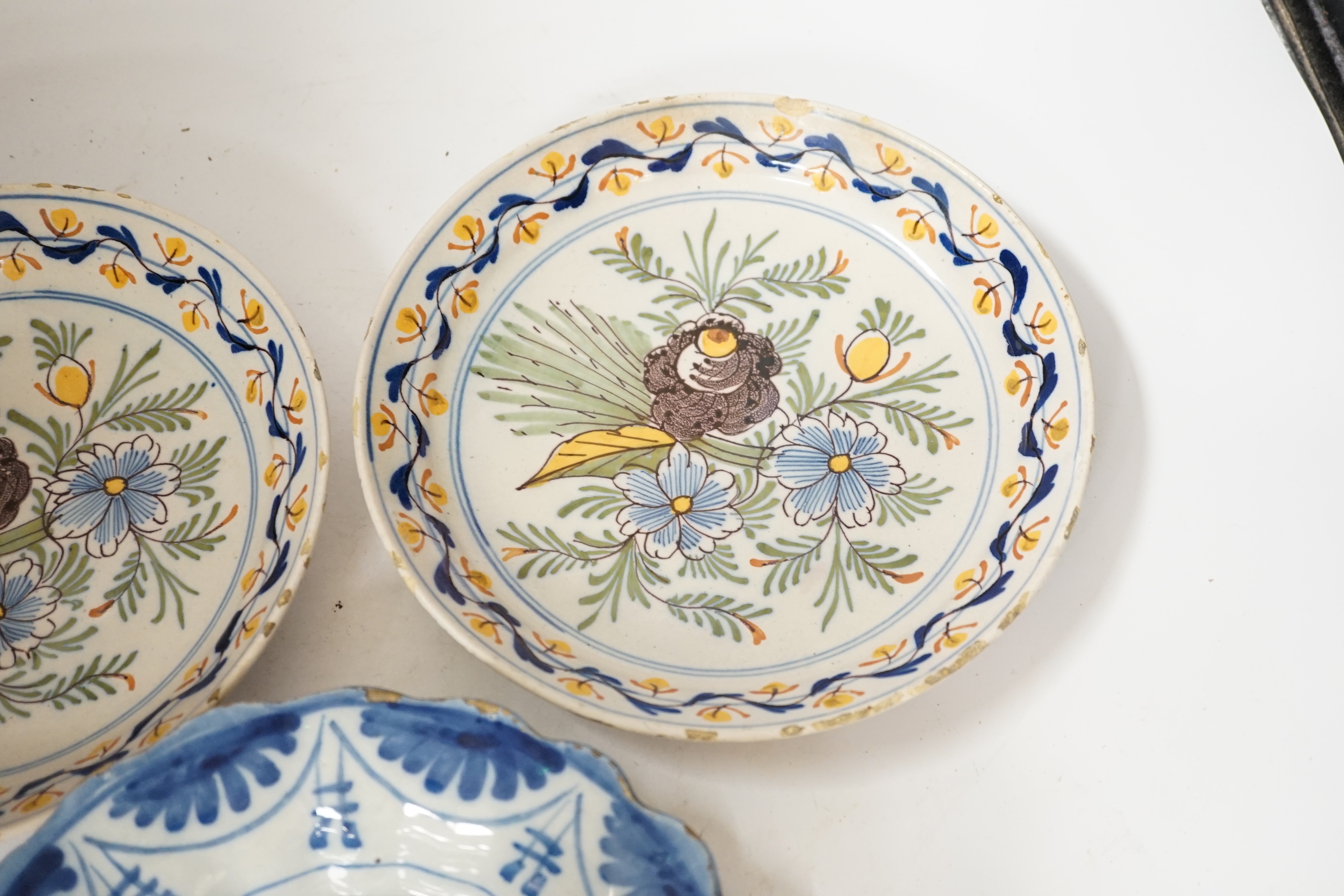 A Delft blue and white dish, c.1700 and two 18th century Delft polychrome dishes, 22cm (3)